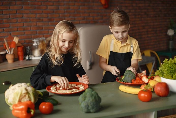 Kinder essen und schneiden Obst und Gemüse