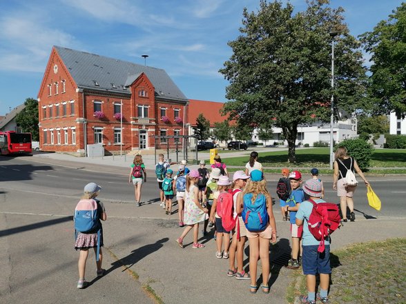 Kinder laufen Richtung Rathaus über eine Straße