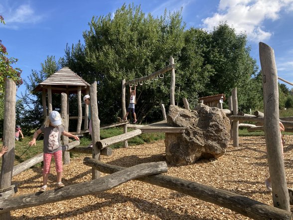 Kinder spielen auf einem Holzspielplatz